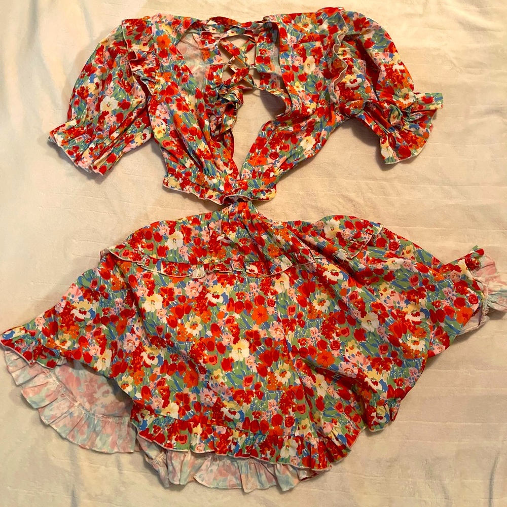Floral Luxxel romper with cross back design. Never worn, still has tag. Medium.
